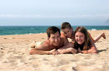 在海滩上玩家庭乐孩子家庭幸福童年乐趣女士旅行海滨团体闲暇图片