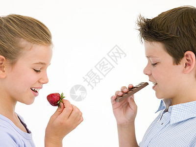姐姐吃草莓 兄弟吃巧克力吧 吃草莓食物女孩女性影棚男生情感孩子们水果青年糖果条图片
