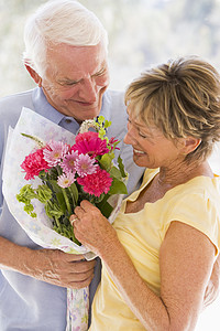 丈夫给妻子送花和微笑感情女性男人退休礼物纪念日两个人周年情感惊喜图片