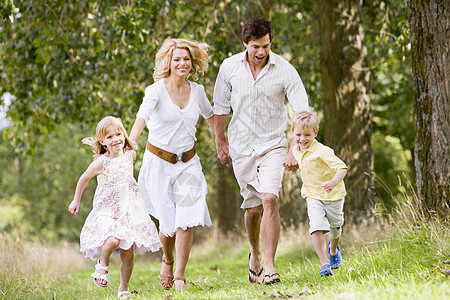 家人在路上举手微笑地奔跑森林女孩农村林地公园树木微笑相机四个人孩子图片