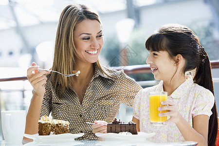 在餐馆的妈妈和女儿 一起吃甜甜点 微笑焦距女儿们女性大窗咖啡杯情绪人种饮料家庭咖啡图片