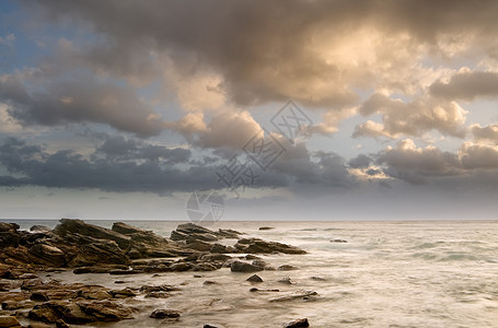 岩石海岸和美丽云彩的风景天堂太阳蓝色石头日落假期海岸线支撑天空海浪图片