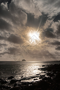 和强烈的光效应支撑地平线日落海洋石头太阳天空风景海岸海岸线图片