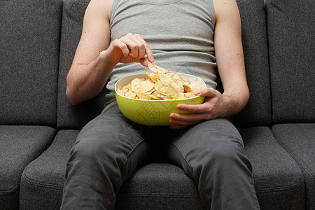 男人吃薯片土豆薯条电视椅子沙发手表零食食物长椅学生图片