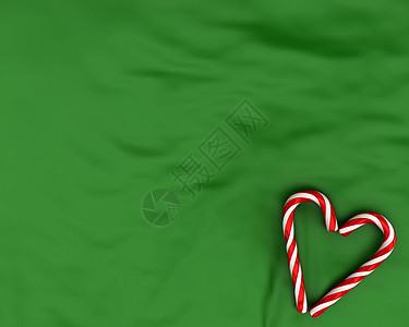 以绿色背景的圣诞糖果制成的心图片