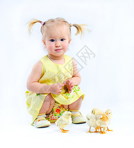 小女孩和小萌鸡穿黄色洋装的可爱小女孩 和真正的活鸡喜悦动物孩子衣服童年生活头发眼睛幸福居住背景