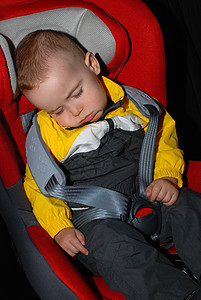 小男孩睡在汽车座椅上图片