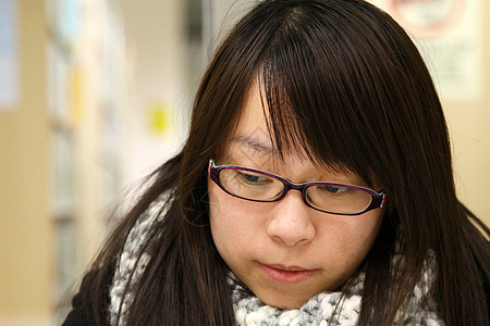 亚裔妇女在图书馆中思考和学习女士教育工作学生笔记本女孩知识班级微笑大学图片