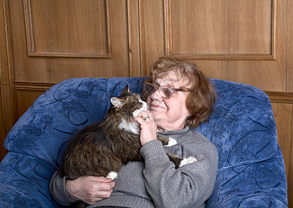 和一只猫坐在椅子上的老女人图片