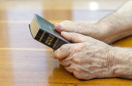 持有圣经家具男性祷告宗教桌子木头信仰黑色男人背景图片