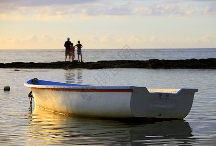 日落时在海滩附近的船水高清图片素材