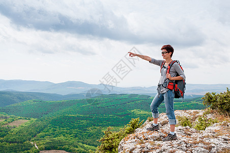 山上的女性天空岩石地平线日出背包顶峰登山者阳光公园自由图片