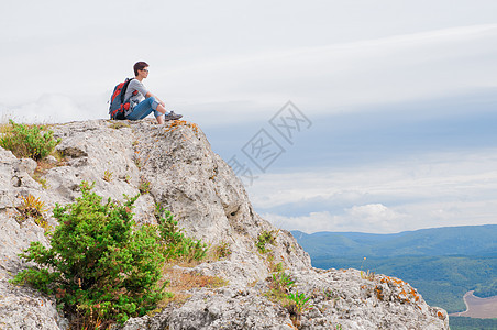 山上的女性远足冒险阳光石头游客运动天空公园悬崖爬坡图片
