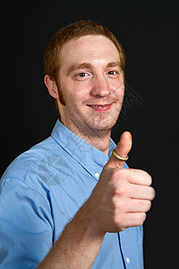 带着拇指笑笑的年轻人白色男性手势灰色男人青年快乐情感学生喜悦图片