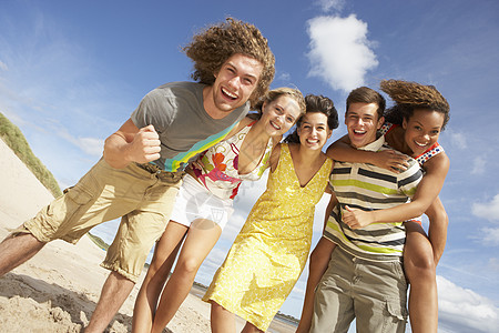 夏日沙滩玩乐朋友团体朋友们女性沙丘混血青少年蓝天水平微笑笑声假期图片