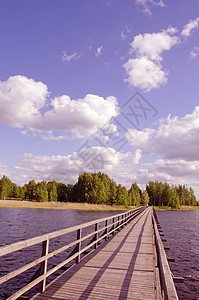 长木桥旅游森林蓝色踪迹公园天空冒险扶手木头小路图片