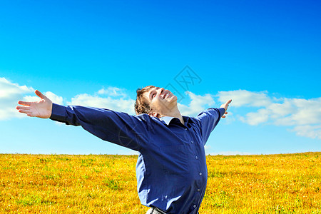 快乐的年轻人享受深色翅膀草地乐趣蓝色地平线阳光幸福自由图片