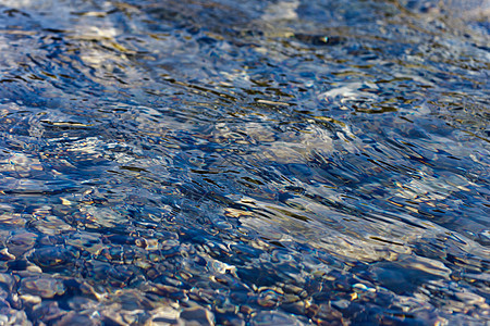 水下石块鹅卵石反射蓝色石头巨石池塘波浪微光太阳波纹图片