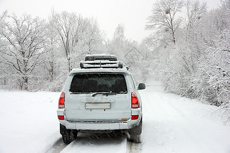 在一辆无法辨认的汽车后面的寒冬雪小路冻结季节天空风险低角度晚会农村警告街道车辆图片