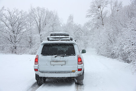 在一辆无法辨认的汽车后面的寒冬雪小路牵引力晚会冻结地平线太阳街道农村车辆运输警告图片