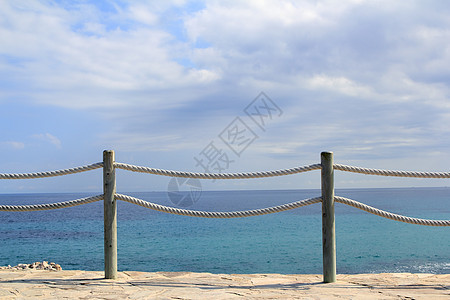 海上绳索和木柴上的护栏旅游晴天栏杆蓝色海岸线海滩地平线环境青色假期图片