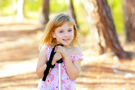 在公园森林中笑着微笑的美丽女孩远足喜悦女孩树木金发孩子松树孩子们乐趣季节图片