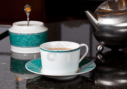 不锈钢杯子来自不锈钢铁茶壶的茶飞碟餐具时间勺子厨房台面液体早餐杯子酿造背景