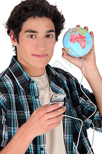 一个十几岁的男孩 拿着手机与一个地球相连图片