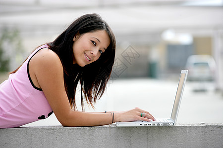 女孩在街上使用笔记本电脑图片