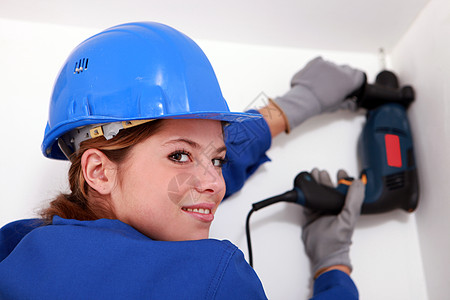 从事电钻的妇女钻孔蓝色装修房子手套工具工作角落长发职业图片