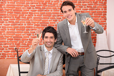 两位青年商务人士庆祝成功年庆典;背景图片