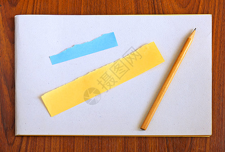 木制背景的空白笔记本和铅笔及撕扯纸图片