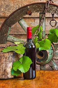 葡萄树背景的酒瓶子酒精食物玻璃文化庆典随行软木木头季节场景图片