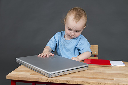 带有灰色底笔记本电脑的婴儿婴儿儿童桌子电子产品电子机构办公室技术背景孩子童年图片