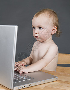 带有灰色底笔记本电脑的婴儿婴儿童年电子产品机构背景桌子孩子办公室技术电子儿童图片