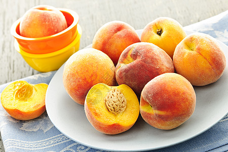 盘子里的桃子圆形菜肴石头水果黄色红色生产桃核服务食物图片