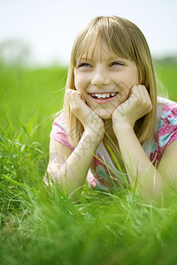 快乐的小女孩户外童年情绪草地晴天女孩乐趣太阳头发孩子闲暇图片