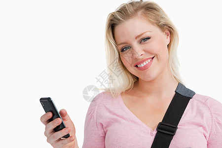 金金发女人在写短信时拿着她的手机图片