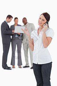 技术工人女商务人士和她后面的同事通了电话背景