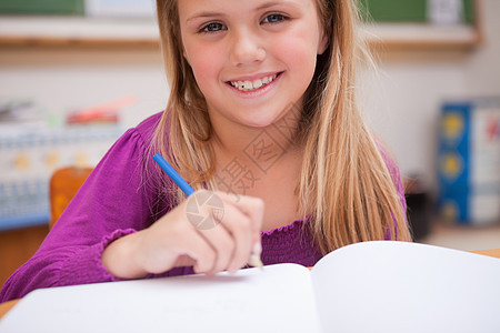 一个年轻女学生写作的近身图片