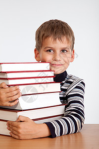 中学生和一堆书学习学校微笑桌子快乐知识课堂瞳孔童年白色图片