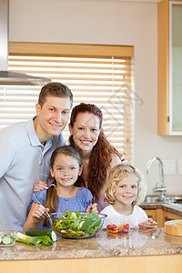 家庭在厨房里站着素食者四个人饮食食物微笑维生素美食夫妻男人女孩图片