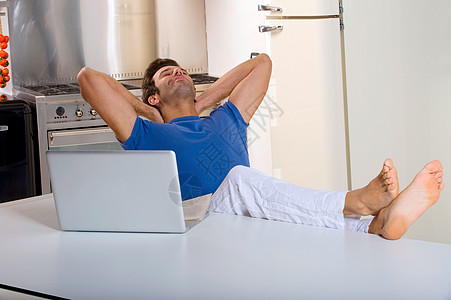 男人在厨房用笔记本电脑通讯互联网双腿网络房子桌子工具信息技术满意度成人图片