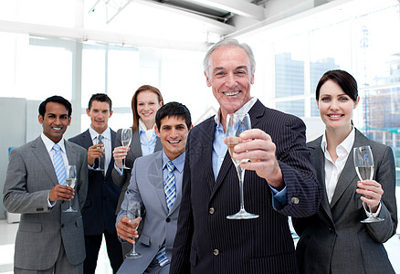 快乐的多样化商业团体 用香槟举杯敬酒庆典多样性职员伙伴乐趣雇员女性办公室公司派对图片