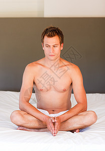 做瑜伽的年轻男孩在床上动起来背景图片