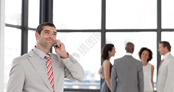 与他的团队在办公室里通过电话交谈的博爱商务人士图片