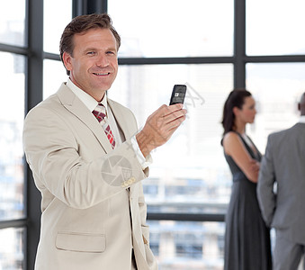 与他的团队在电话上对一个愉快的商务人士的肖像图片