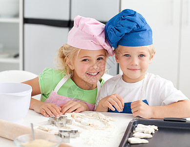 两个可爱孩子的肖像 在厨房里烘烤图片