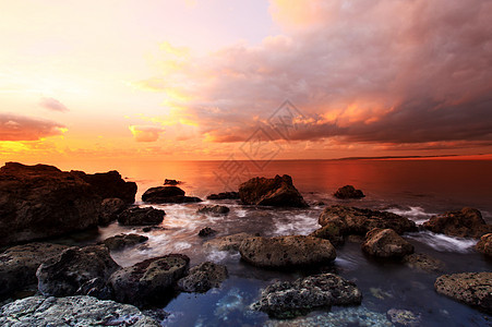 海湾日落地平线波浪太阳风景黄色海洋岩石海岸线反射海滩图片