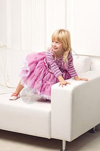 小女孩在沙发上快乐地装扮喜悦姿势拥抱家庭吊带裤紫色微笑裙子房间孩子图片